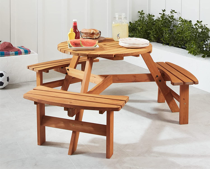 A wooden outdoor picnic table featuring three built-in benches for seating.