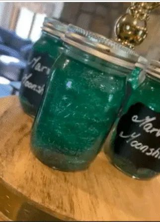 Blue glitter swirling in a mason jar filled with drink.