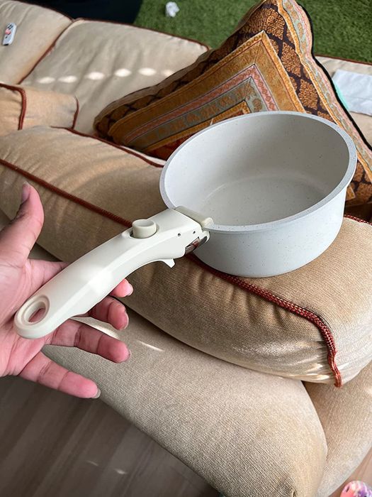 A reviewer's photo showing the handle attached to one of the pots, demonstrating how the detachable feature works.