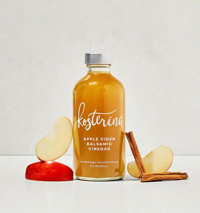 Kosterina Apple Cider Balsamic Vinegar bottle accompanied by apple slices and cinnamon sticks