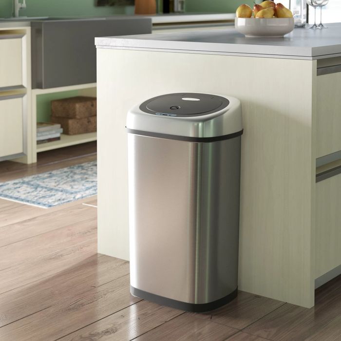 The motion-sensor trash can sitting in a kitchen.