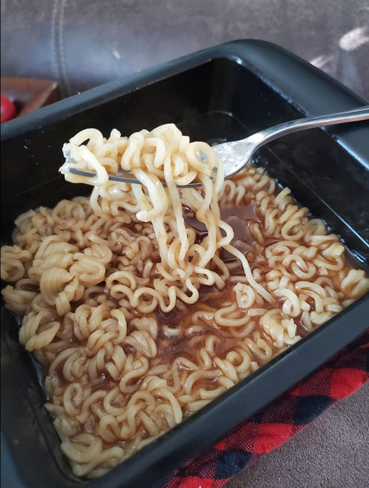 A reviewer’s cooked ramen resting in a square silicone ramen cooker