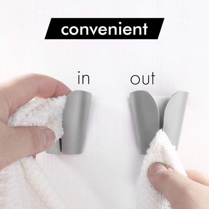 A hand demonstrating the easy process of placing and removing a towel from a wall-mounted towel hook.