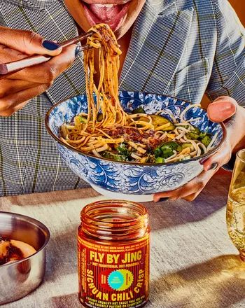 a person enjoying noodles with the chili crisp sauce