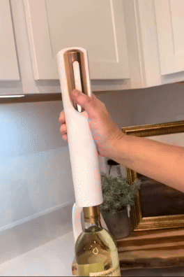 An automatic wine bottle opener in use, effortlessly removing a cork on a kitchen counter.