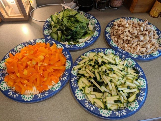 Four plates stacked with freshly diced vegetables, all chopped using the veggie dicer.