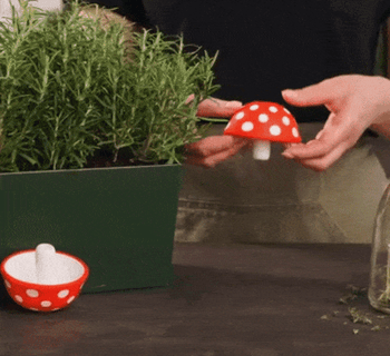 A gif showing someone flipping the mushroom funnel inside out and using it to pour oil into a bottle