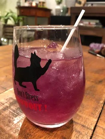 Pink glitter in a wine glass with a drink inside.