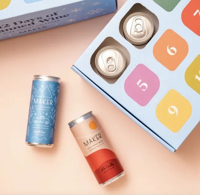two cans of wine next to a wine Advent calendar