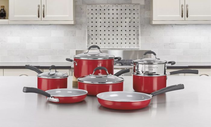 The 11-piece red and gray cookware set arranged on a kitchen counter.