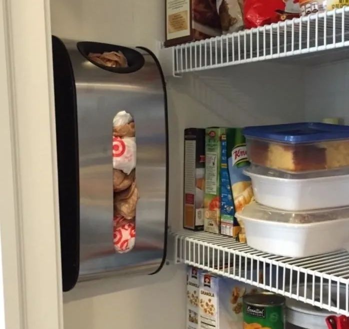 A reviewer’s photo shows a stainless steel dispenser with a circular hole at the top and a rectangular hole in the center, mounted to the wall in a pantry