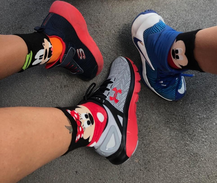 a reviewer and her children wearing socks featuring Mickey, Minnie, and Donald