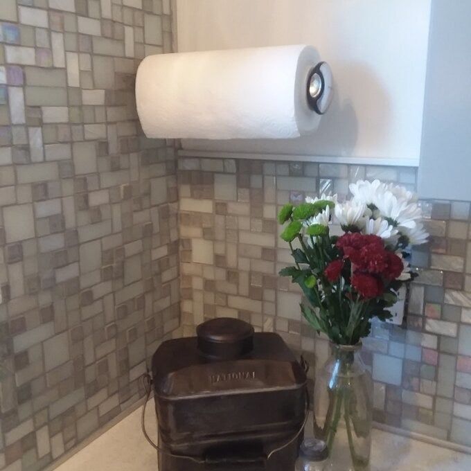 The towel rack in use, holding a roll of paper towels.