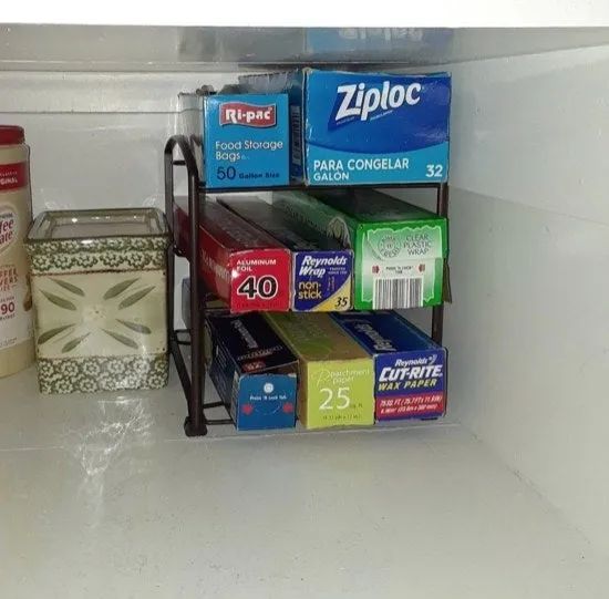 A bronze plastic wrap storage unit neatly holding wrap inside a cabinet