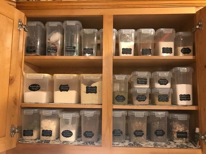The same cabinet with food neatly stored and organized in clear, labeled containers