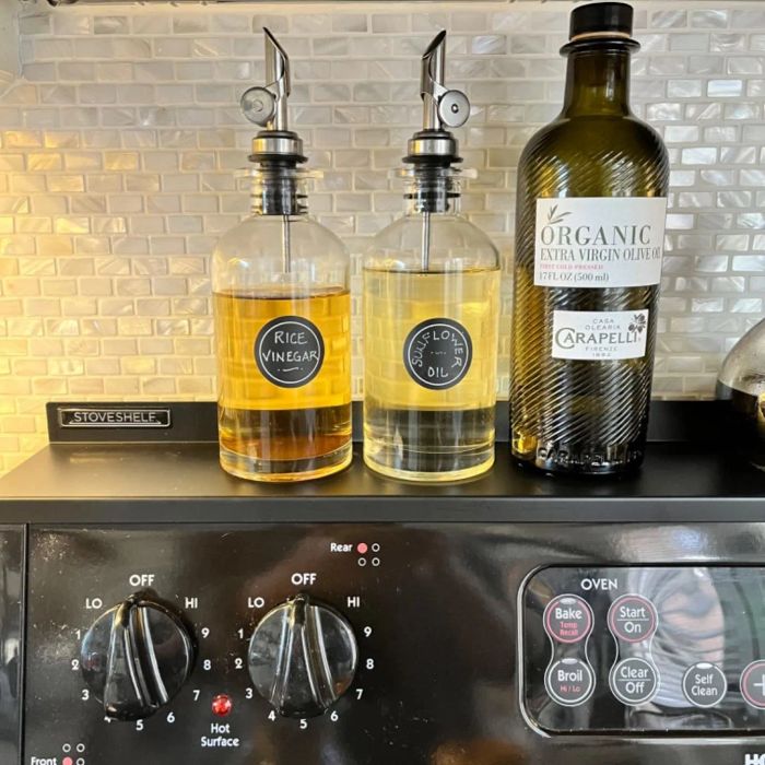 A stove shelf in a reviewer's home with oil bottles placed on it