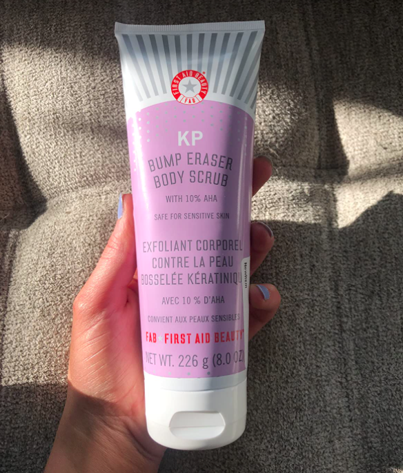 A customer review photo of them holding the bottle of the KP Bump Eraser Body Scrub.