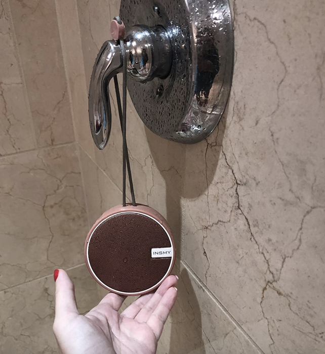 A customer review photo showing their speaker hanging from the shower knob