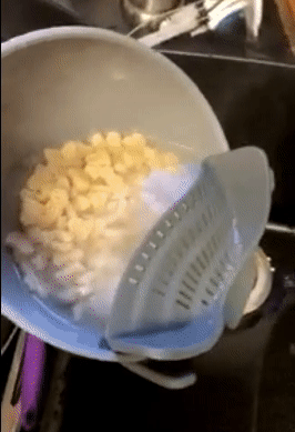 A gif showing a reviewer using the gray Snap N' Strain to drain water from a bowl of pasta