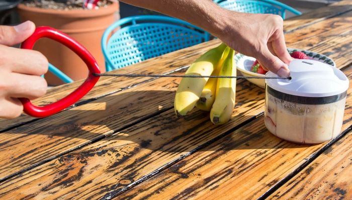 A person pulling a cord attached to the food processor to purée the ingredients