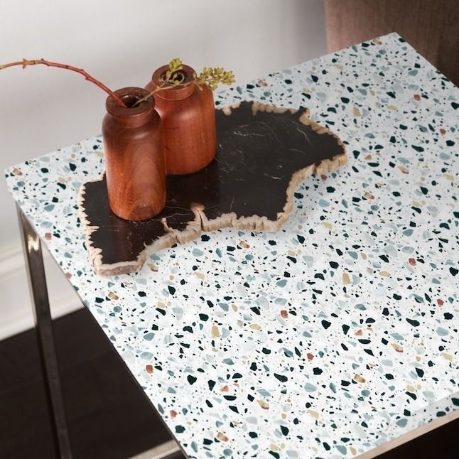 A terrazzo-covered side table adorned with decorative items