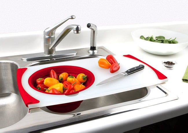 a white and red cutting board with a built-in strainer