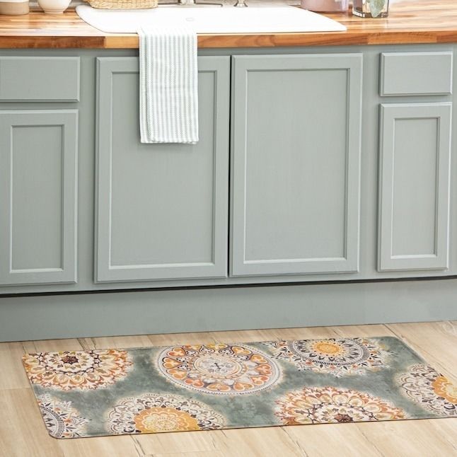 A patterned floor mat placed in front of kitchen counters for added style and comfort