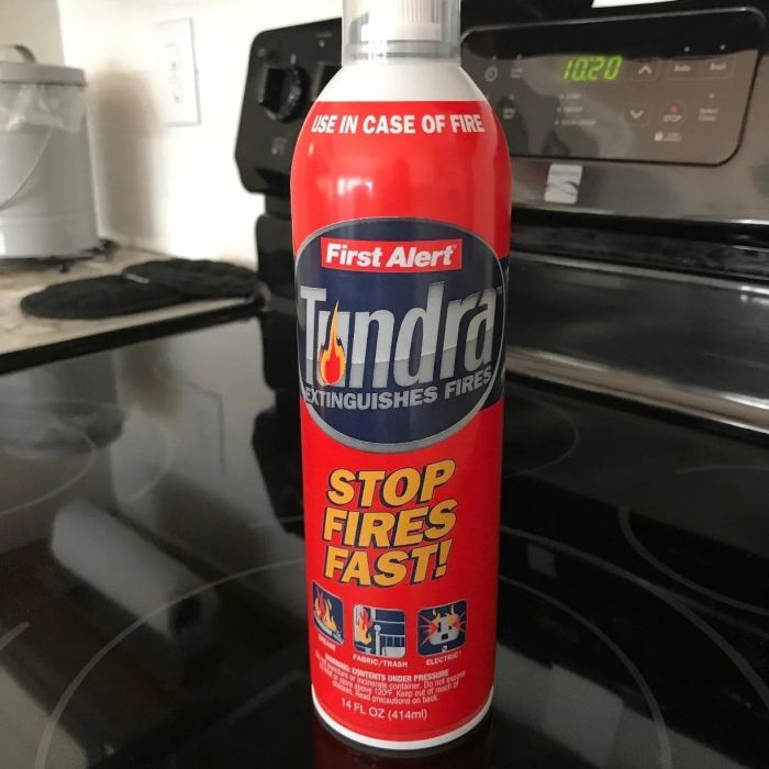 A can of Tundra brand fire-extinguishing spray resting on a stovetop.