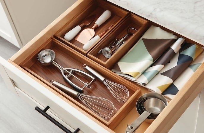 Three dividers for organizing kitchen utensils in a drawer.