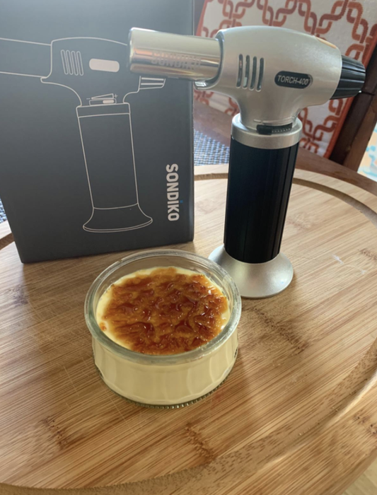 A reviewer's photo featuring a blow torch and a perfectly made creme brulee