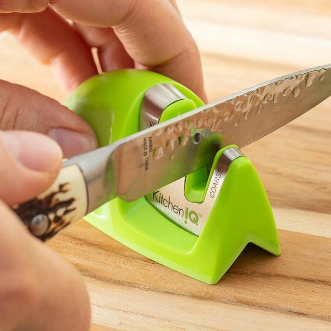 Someone sharpening their knife using the compact, handheld tool