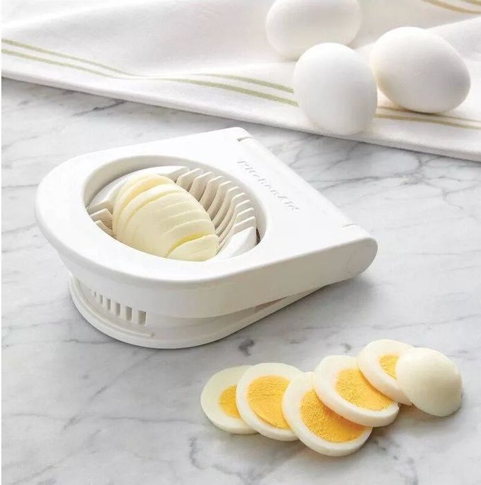 The egg slicer cutting through a hard-boiled egg into multiple slices