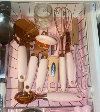 The gadgets in a drawer with copper heads and soft pink handles