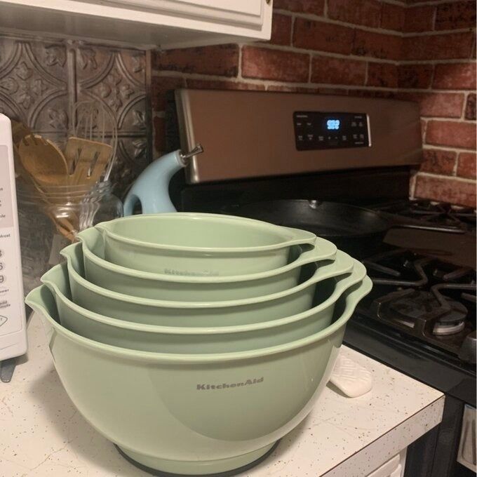 Stacked KitchenAid mixing bowls sitting on a kitchen counter near a stove and a toaster