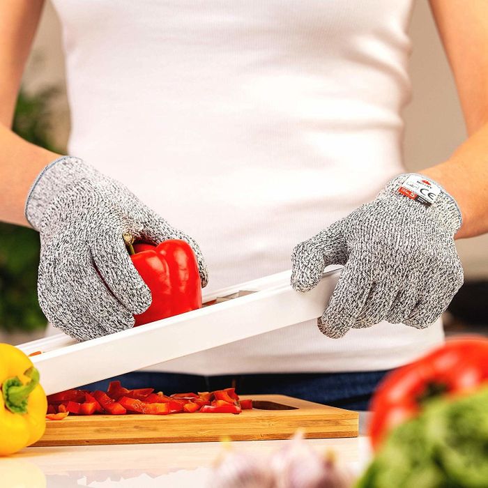 a reviewer using the gloves to slice a pepper with a mandolin slicer