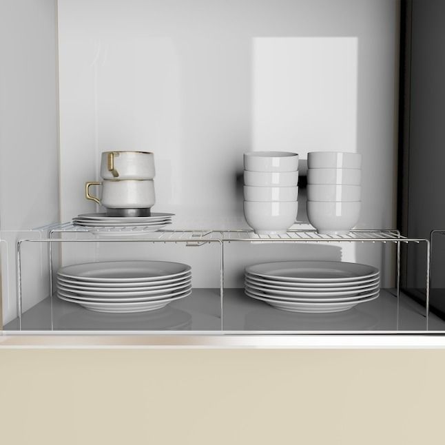 A cabinet shelf organizer neatly stacked with plates, bowls, and cups