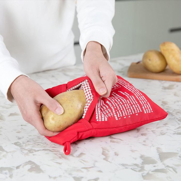 A model placing a potato into the microwave cooking bag