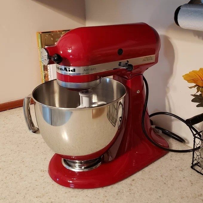 A close-up image of a red KitchenAid stand mixer, showcasing its sleek design and features