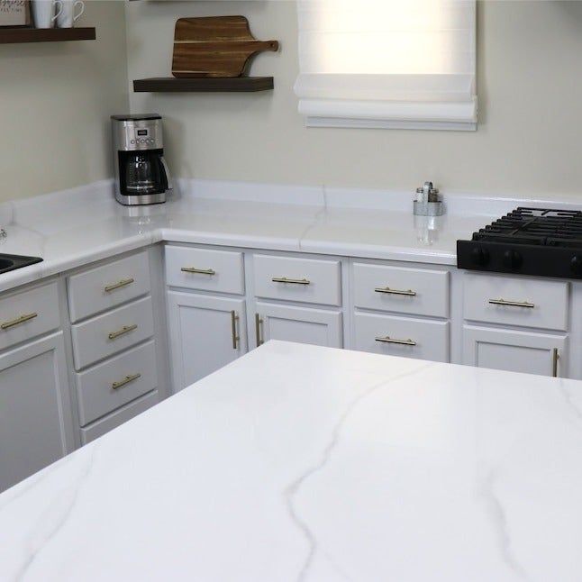 Elegant white marble countertops paired with a matching island, offering a clean and luxurious kitchen look.