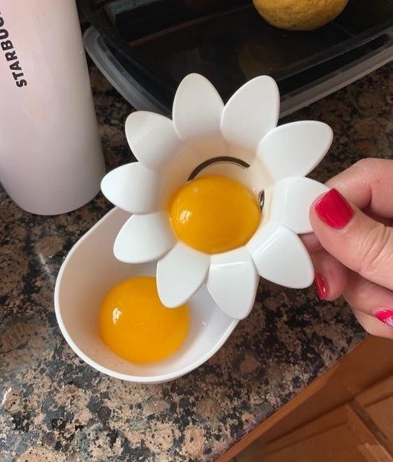 A reviewer using a white, daisy-shaped tool to separate egg yolks from whites