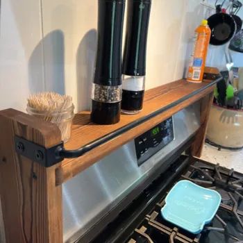 Kitchen stove with a wooden shelf holding salt and pepper grinders, toothpicks, and two containers; timer shows 6:59