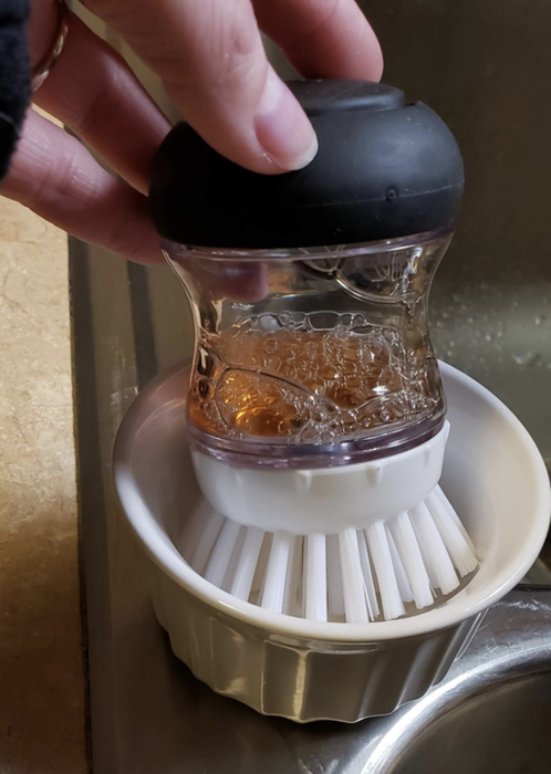 A reviewer's photo showing the soap brush fitting into a small ramekin