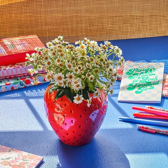 Large strawberry-shaped vase filled with vibrant flowers
