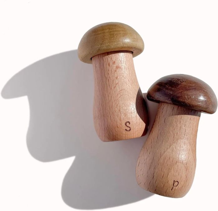 Two mushroom-shaped wooden salt and pepper shakers, featuring a simple, natural wood design