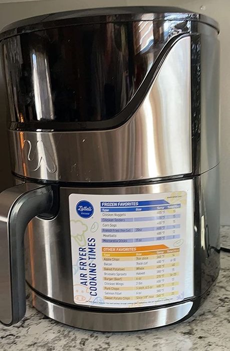 A reviewer’s photo of an air fryer with the smaller magnetic cheat sheet attached to it