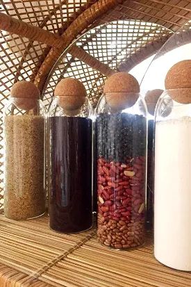 Larger glass canisters arranged neatly on a wicker pantry shelf