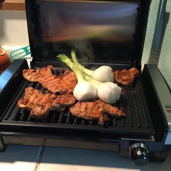 A reviewer cooking food on the indoor grill