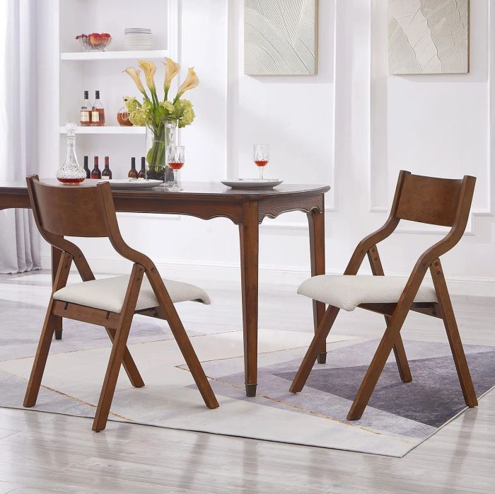 A modern dining set featuring a wooden table with two chairs, each with plush cushioned seats