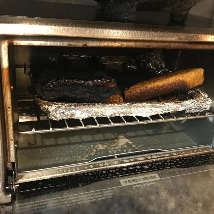 A reviewer's toaster oven, badly burnt, with a charred bagel still inside.