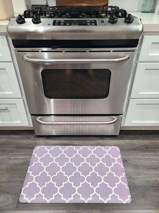 The reviewer's mat placed in front of a kitchen oven for added comfort.